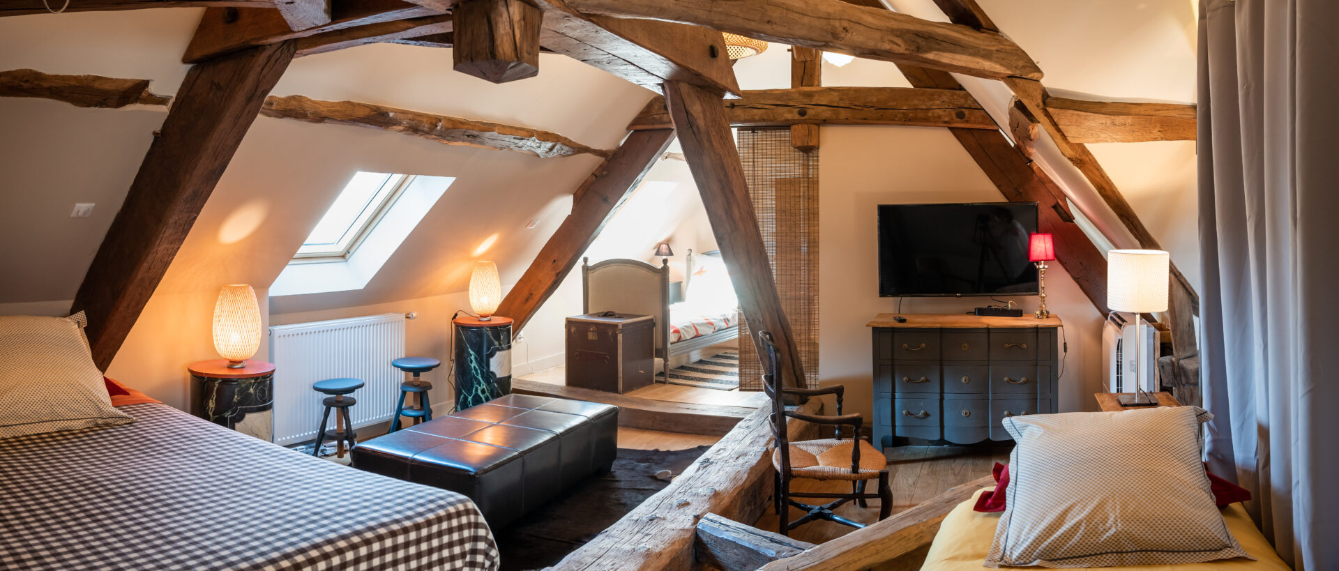 Chambre sous les combles avec lumière naturelle, typique de la région Occitanie.